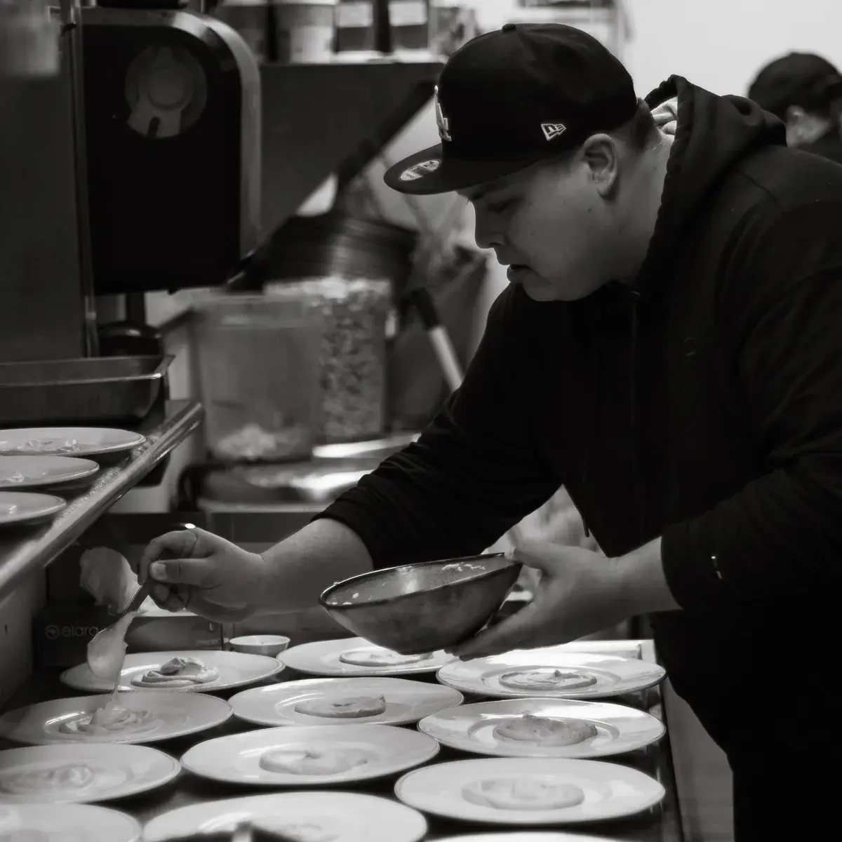 Zay carefully plating desserts in the Khom Fai kitchen